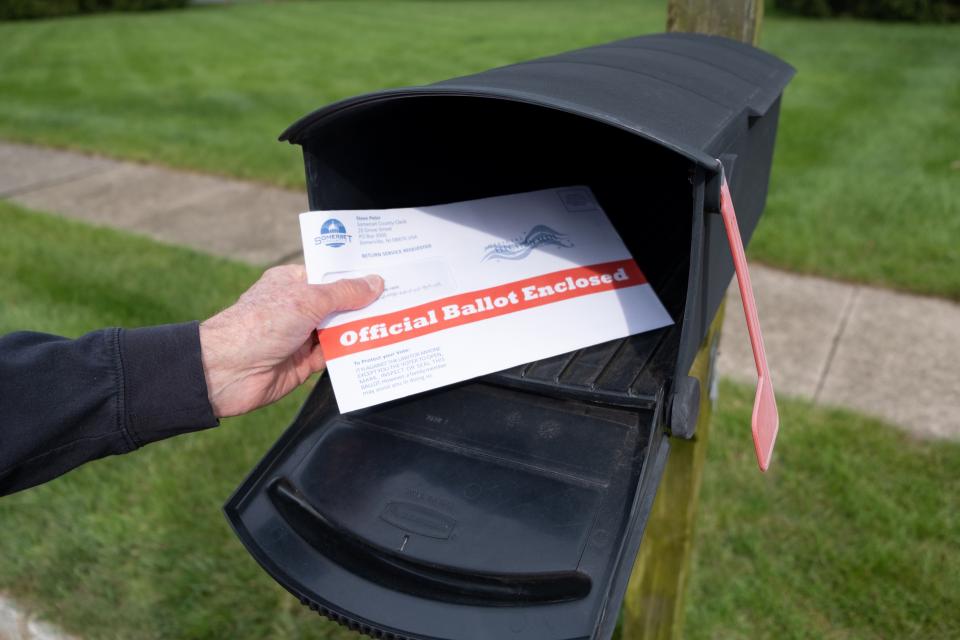 Man depositing an official ballot into a mailbox