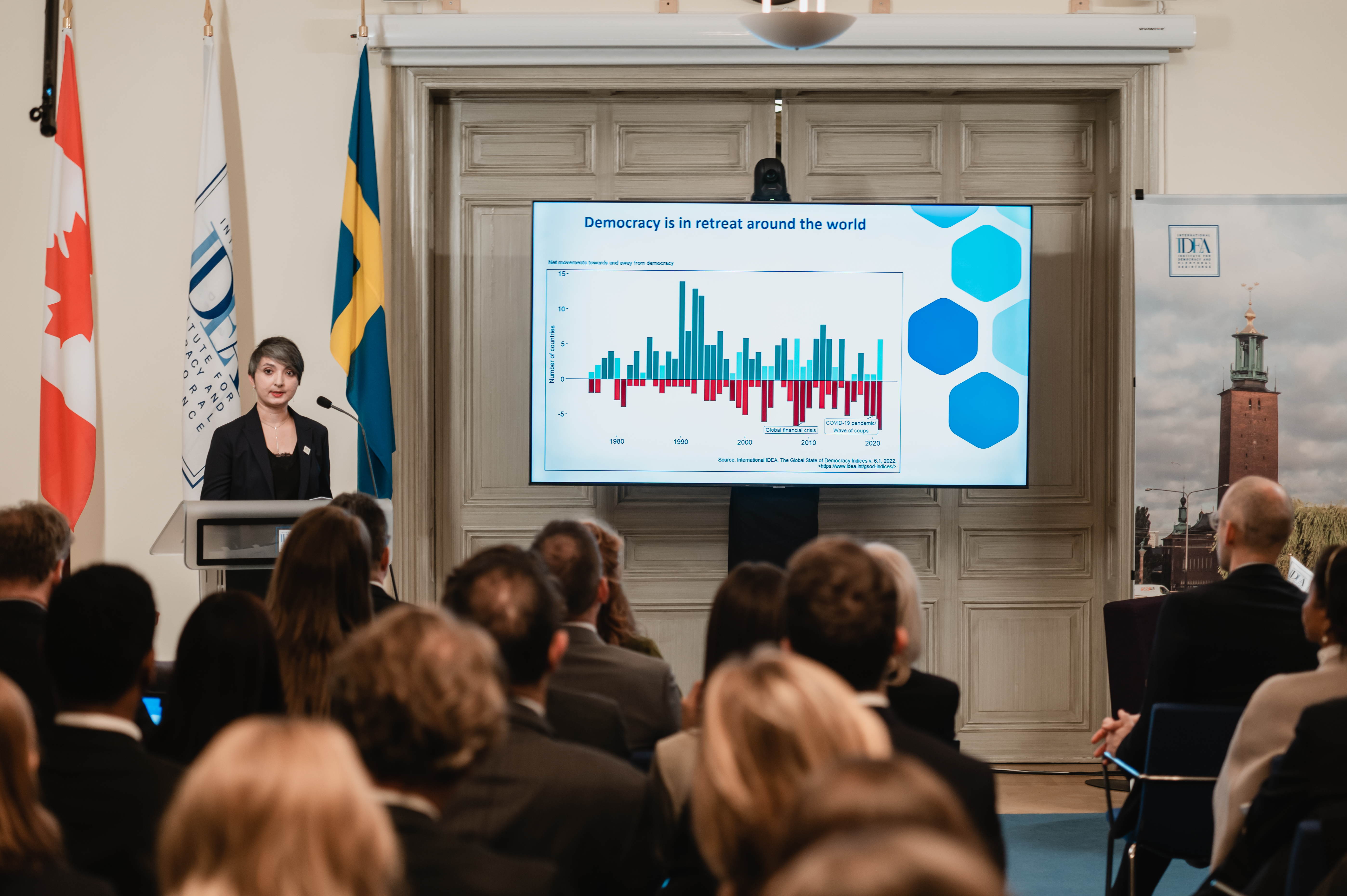 An event participant holds the State of Democracy 2022 Report at the launch in Stockholm. Credit: Malin Huusmann