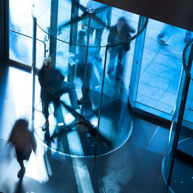 People going into an office building in a revolving door