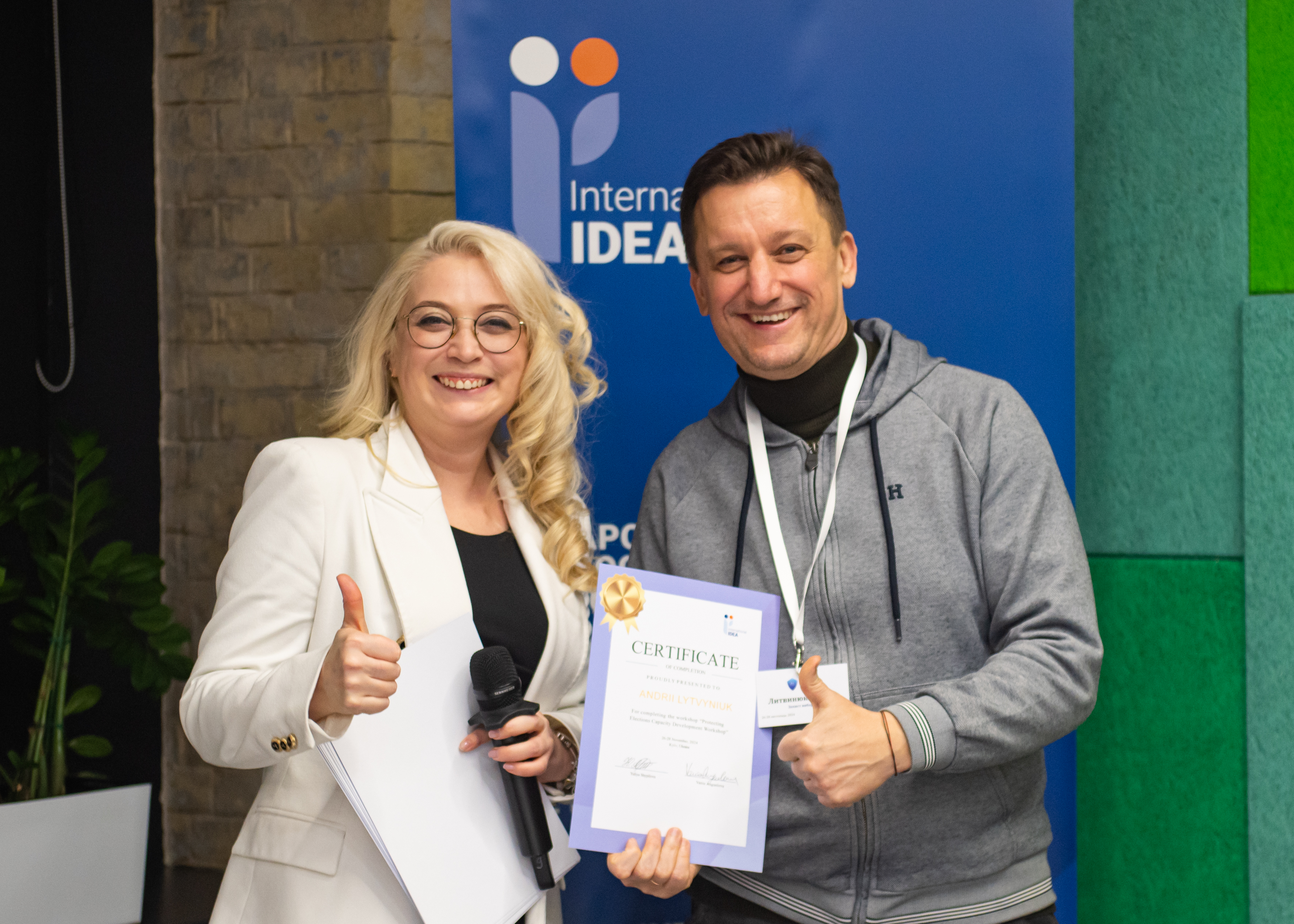 International IDEA Programme Manager Yuliya Shypilova (left) issues a certificate to the Deputy Head of the Department of Administration and Information Protection of the Secretariat of the Central Election Commission, Andrii Lytvyniuk, who participated in a capacity-building workshop on protecting elections in Ukraine, in Kyiv, Ukraine, November, 2024. Credit: Valeriia Landar