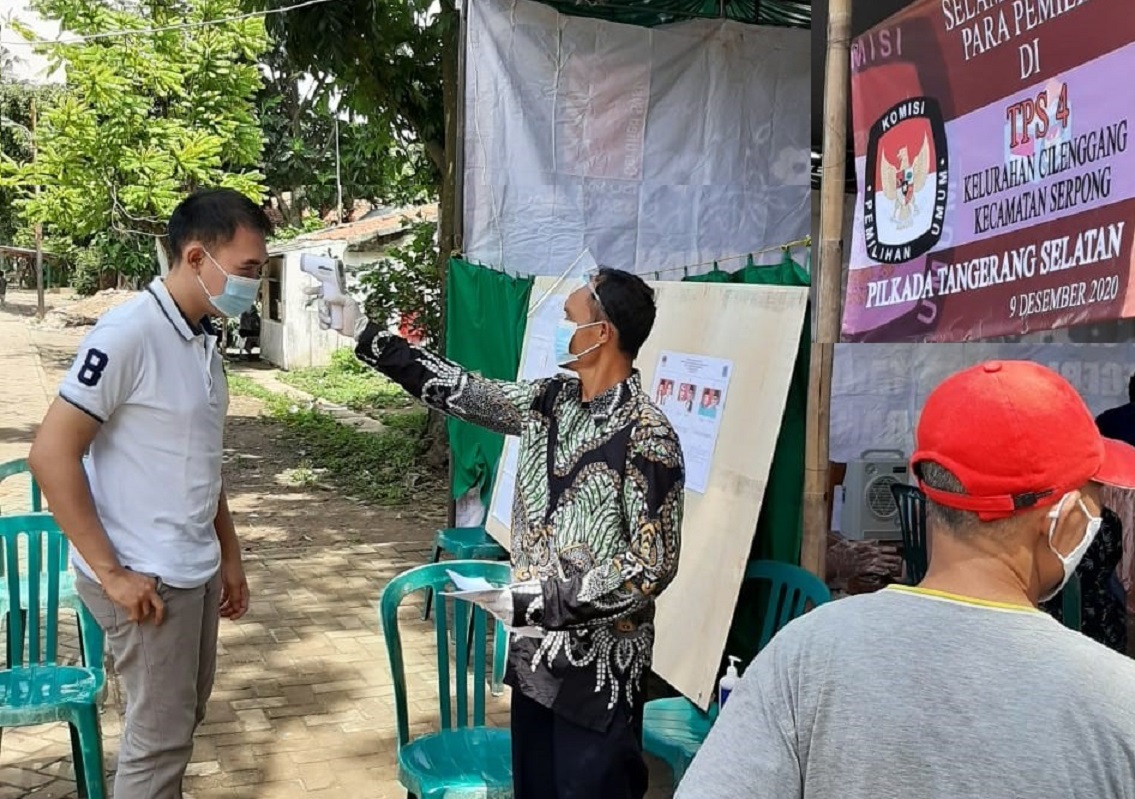 A voter’s body temperature being checked as a safety measure at a polling station in South Tangerang City, Banten Province. Image credit: Hadar Gumay/Netgrit.