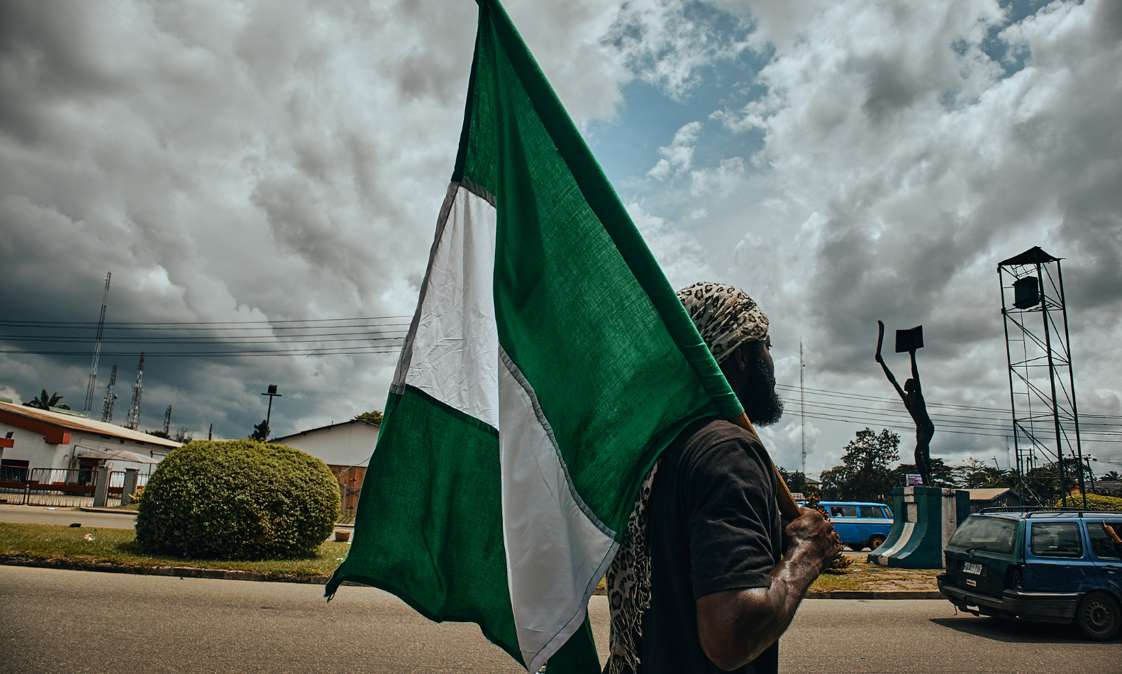 A man walking on the street with Nigeria´s flag over the shoulder