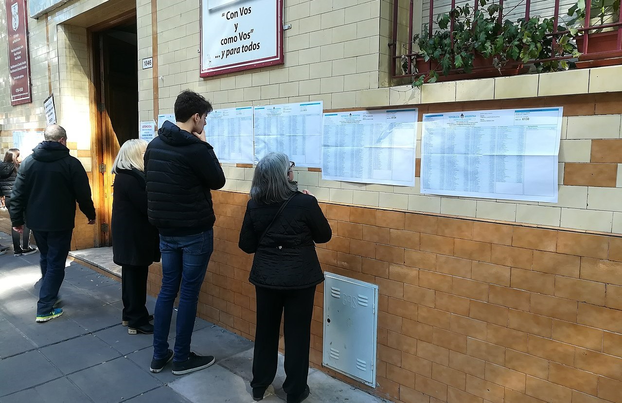Ciudadanos consultan el padrón en un colegio electoral de Buenos Aires, en las elecciones primarias de Argentina de 2019.