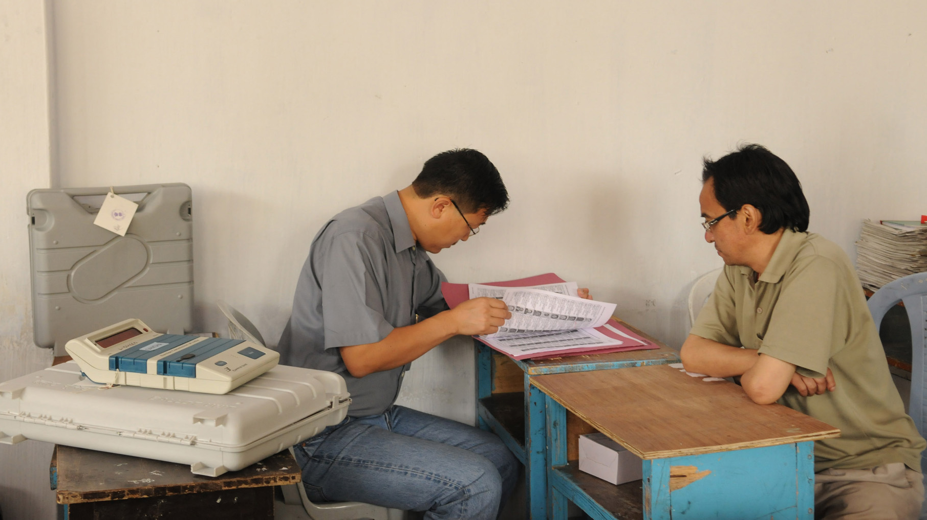 Polling officers going through the voters list collected with the Electronic Voting Machines (EVM).