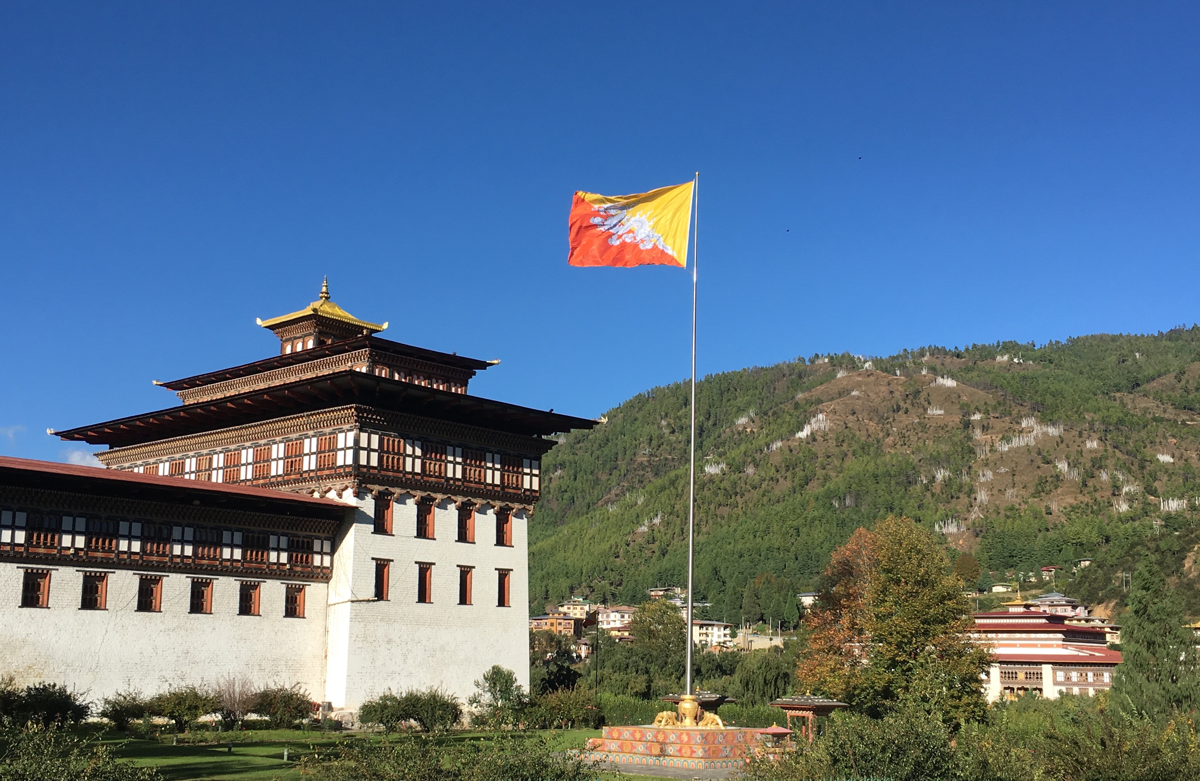 Bhutan flag in front of building.  Photo: Adhy Aman | International IDEA