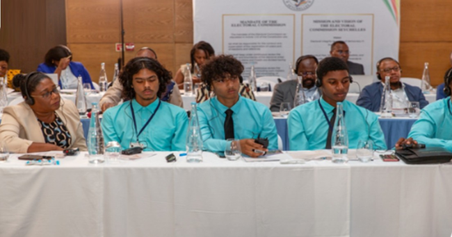 photo of several youth sitting on table listening