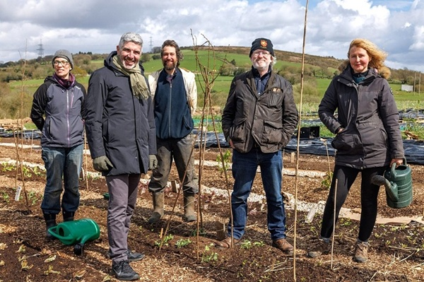 a photo of Derek walker, the commissiner of future generations visiting a community-supported agriculture project in 2024