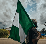 A man walking on the street with Nigeria´s flag over the shoulder