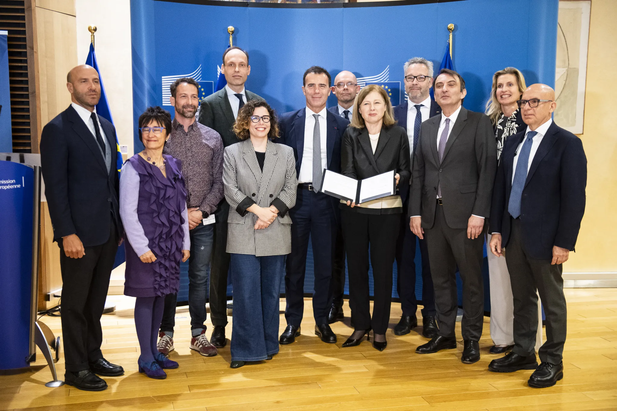 Officials from International IDEA and the European Commission pose for a photo with the leaders of several European political parties following the signing of a code of conduct at the headquarters of the European Commission in Brussels on 9 April 2024. Among the officials are International IDEA’s Director for Europe, Sam van der Staak, and Marilyn Neven, programme manager,  as well as European Commission Vice-President Vera Jourová (holding the signed document). Credit: European Union/Lukasz Kobus. 
