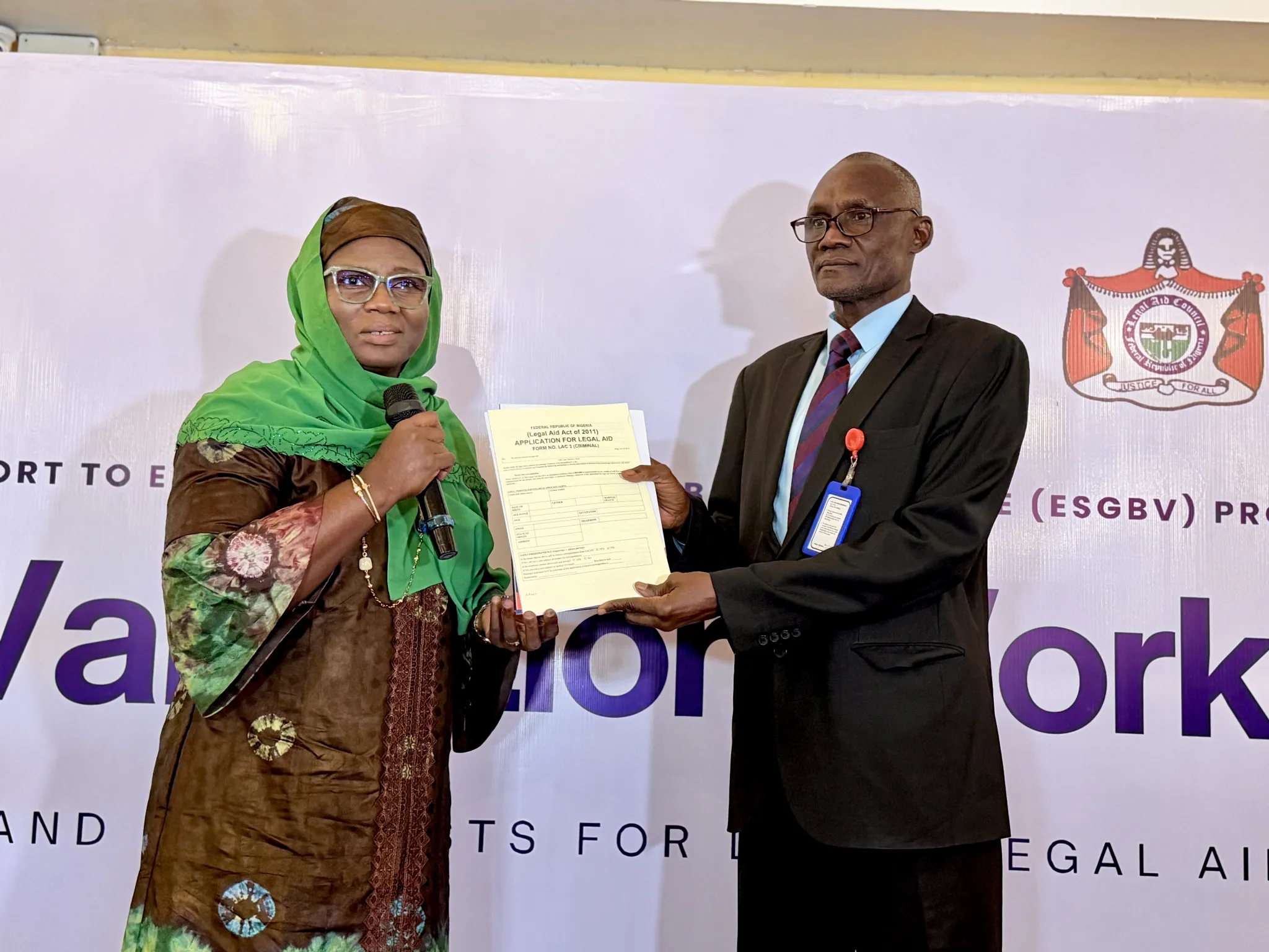 Dr. Mufuliat Fijabi, Senior Programme Manager of the ESGBV Programme, presents the SGBV Identification Guidelines and Checklists for Legal Aid Case Work to Aliyu Bagudu Abubakar, Director-General of the Legal Aid Council of Nigeria.