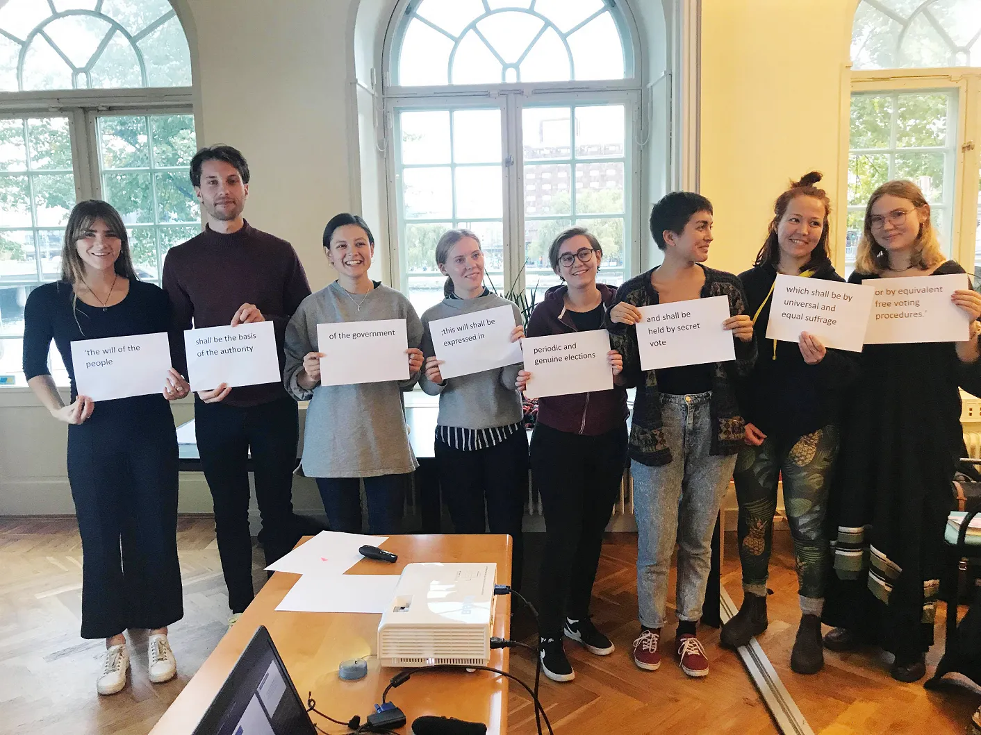 Participants show text from Article 21 of the Universal Declaration of Human Rights after completing an activity. Photo Credit; International IDEA