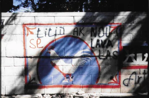 Mural showing the campaign symbol of the fighting rooster with the words  Aristide is US and Lavalas