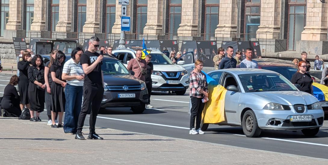 Ukrainians stand outside cars and line road in Maidan Square  to commemorate soldier recently killed in war. Kyiv, May, 2026